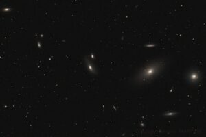 Une astrophotographie montrant de nombreuses petites galaxies organisées en amas