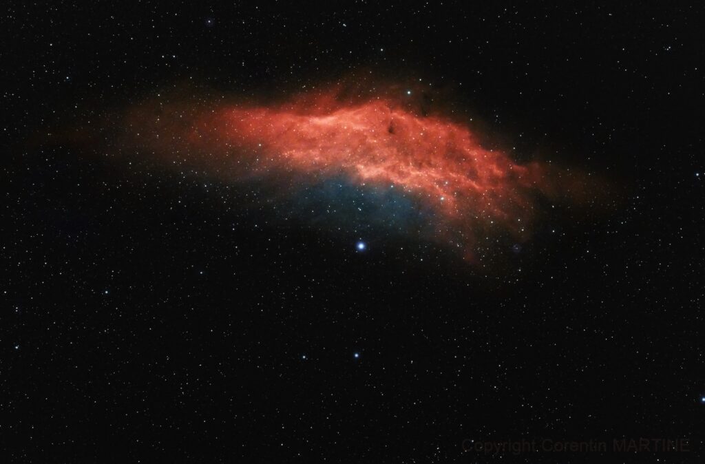 La Nébuleuse Californie Une nébuleuse orangée semble couvrir une étoile bleutée sur font étoilé